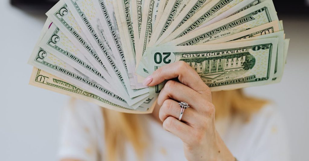 A person holding a fan of US dollar bills, symbolizing wealth and financial success.